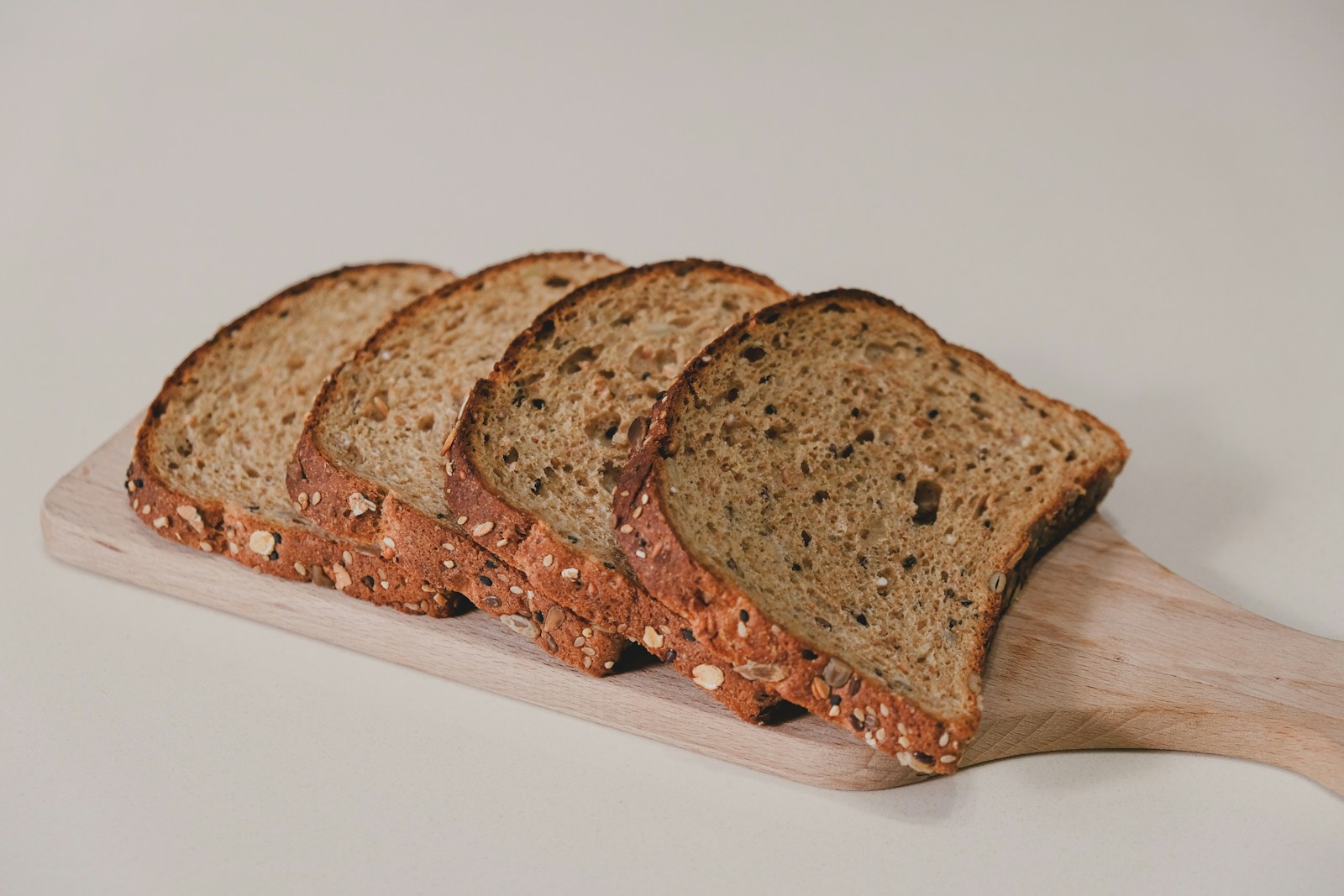 Slices of seeded bread arranged on a wooden board